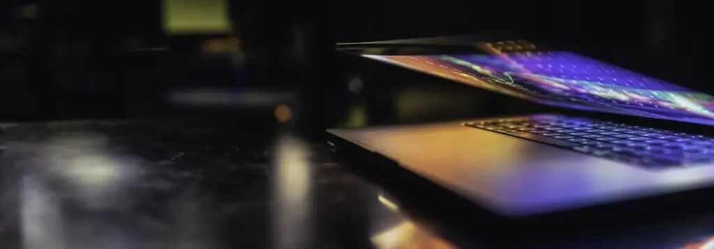 Halvu00e5pen Laptop I Mu00f8rkt Rom Med Lys Fra Skjermen Halvu00e5pen laptop i mu00f8rkt rom med lys fra skjermen